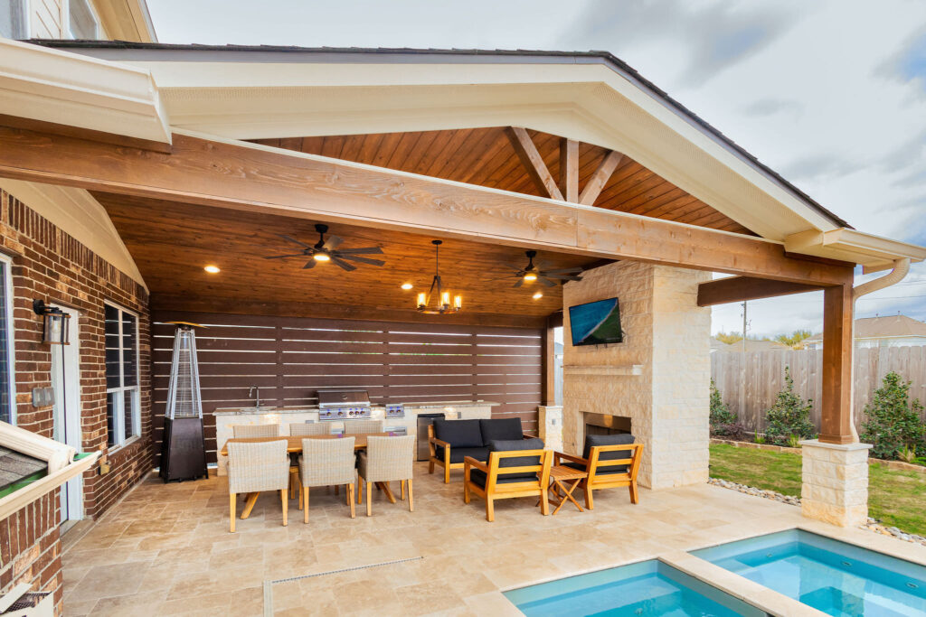Pool side Gable Patio Cover with a Fireplace, Outdoor Kitchen and Privacy Wall.